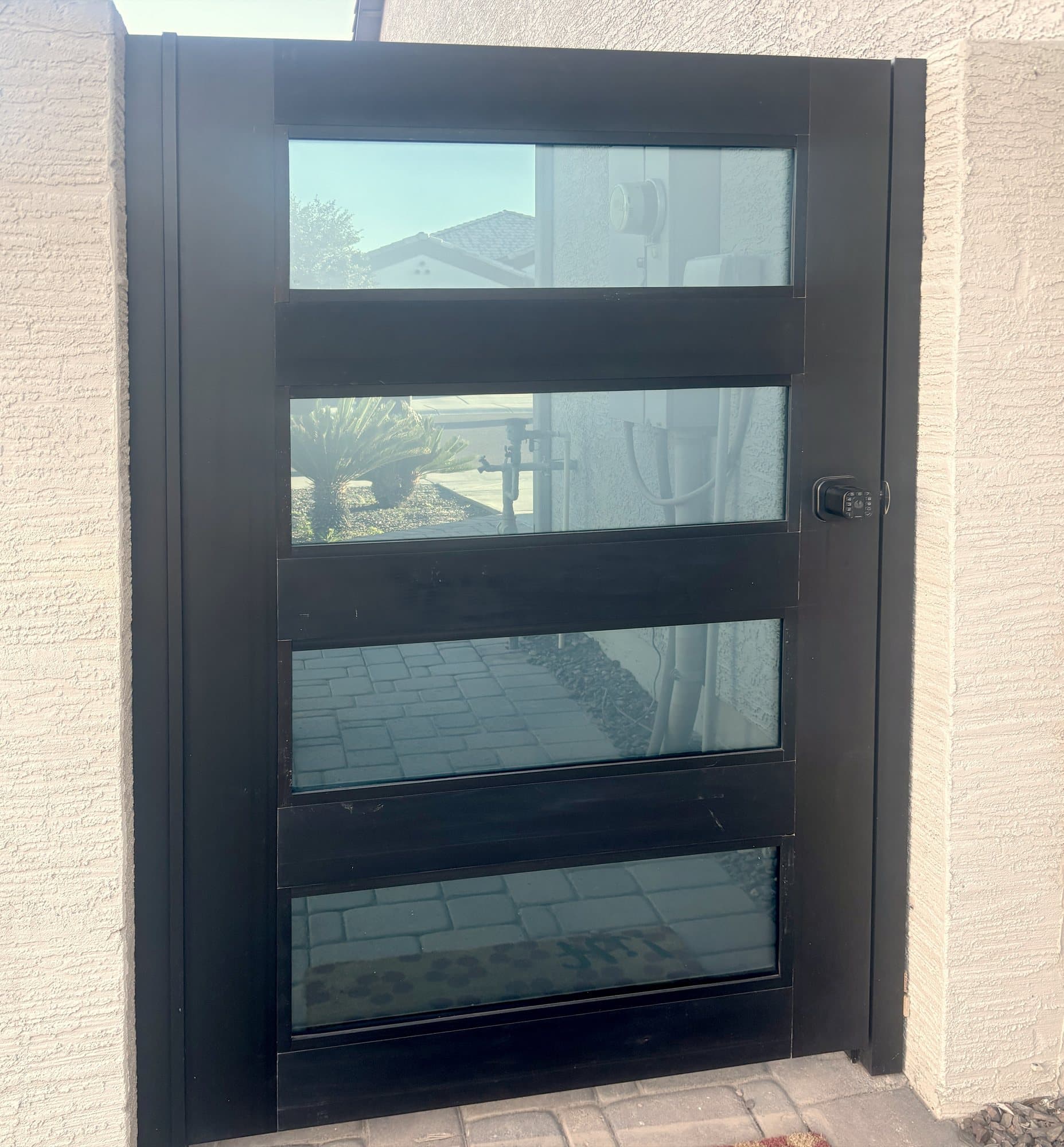 Black modern entry door with four horizontal glass lites, installed by Radiant Wall