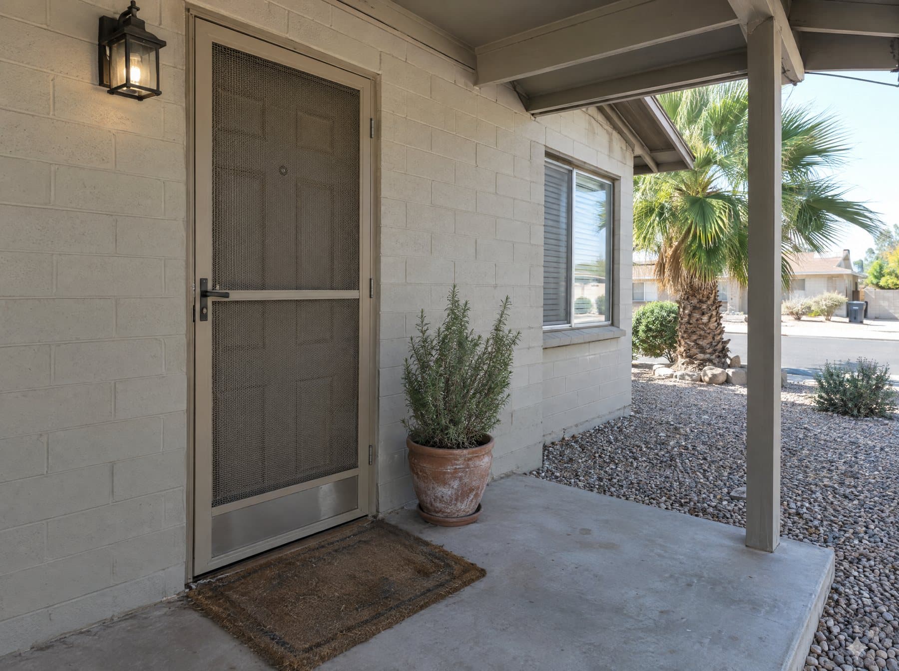 Black aluminum screen door over an entry on a stucco wall