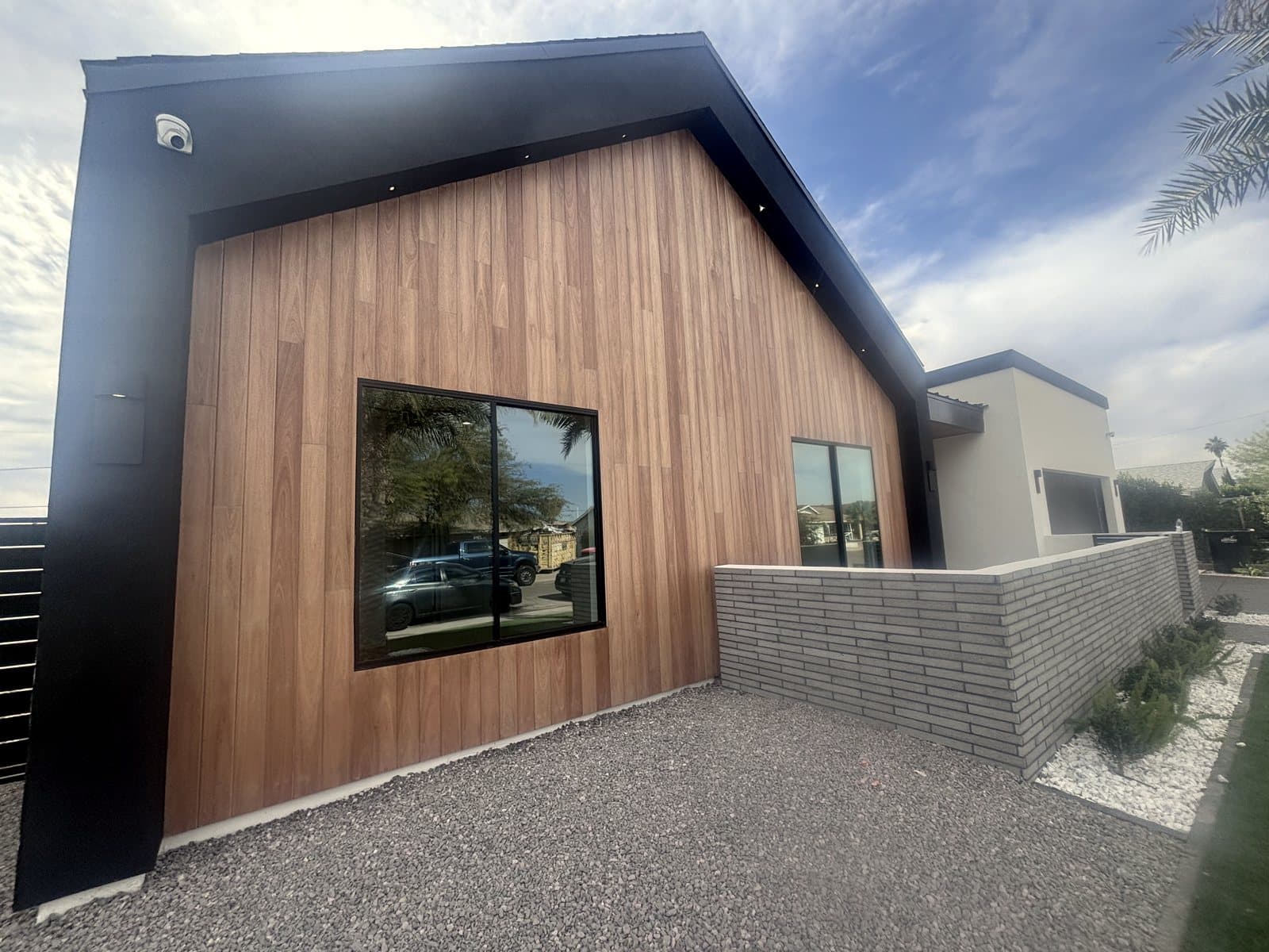 Black-frame picture windows installed in a cedar-clad modern home